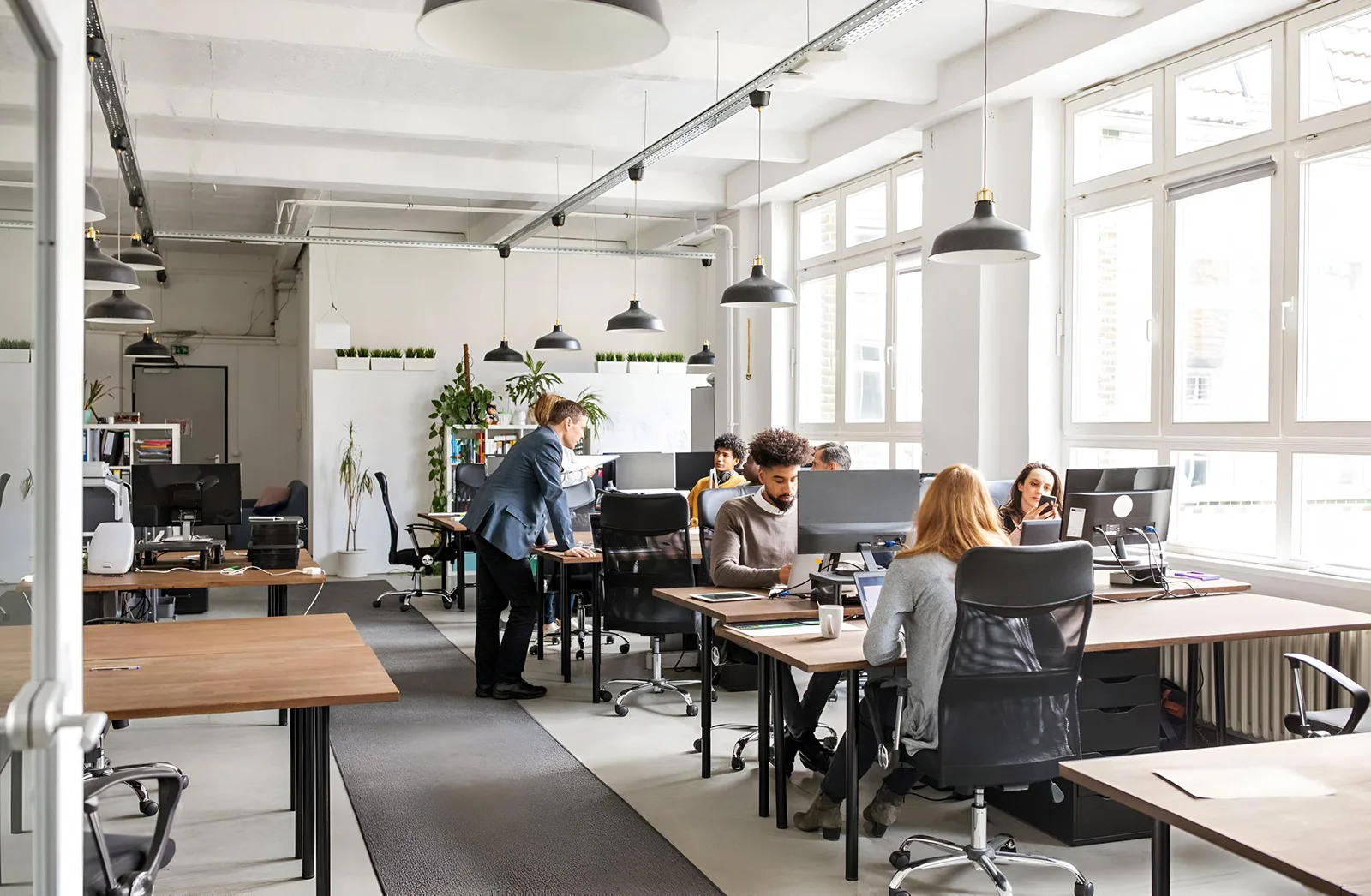 pace-IT Köln – Arbeitsplätze mit ergonomischem Setup und kreativer Wandgestaltung Helle, modern eingerichtete Arbeitsplätze im pace-IT Büro Köln mit ergonomischen Stühlen und farblich gestalteter Wand